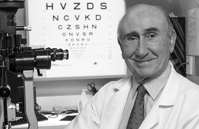 Dr. Evangelos Gragoudas next to a slit lamp in the clinic 