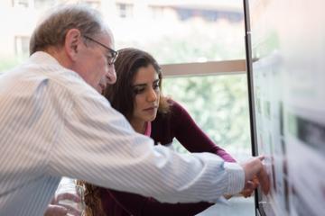 Dr. Delori reviewing a poster with a research fellow. 