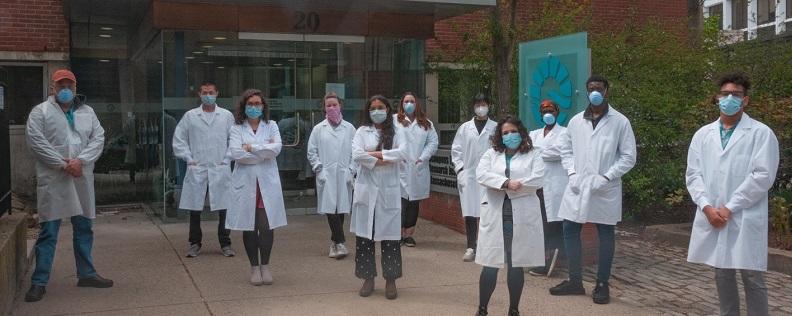 researchers working on the vandenberghe aavcovid vaccine program stand in from of mass eye and ear